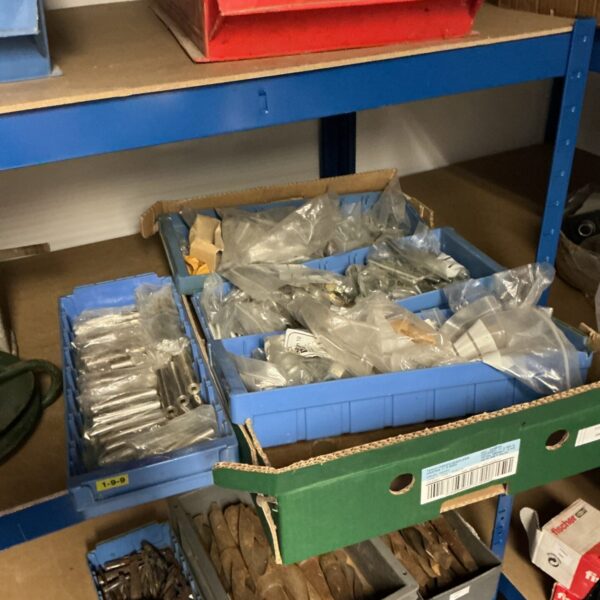 Assorted engineering bolts and hardware in plastic storage bins.
