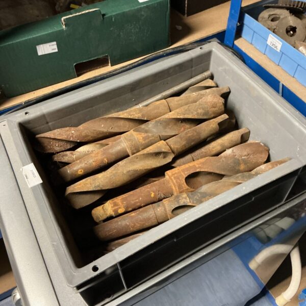 Tray of large industrial drill bits for metalworking.