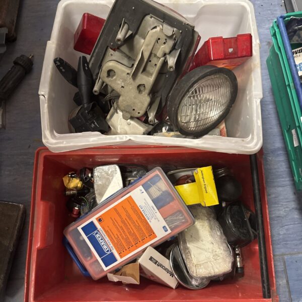 Assorted motoring parts and accessories in a plastic box.