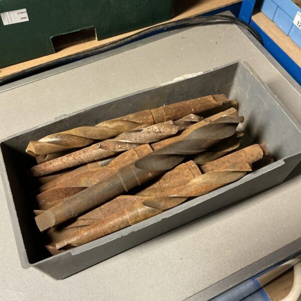 Tray of large drill bits for metalworking and industrial applications.