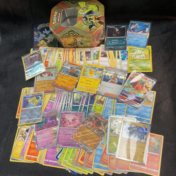 Assorted Pokemon cards inside a collectible tin.