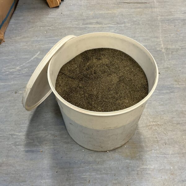 Bucket of fine shot blasting media for surface preparation.