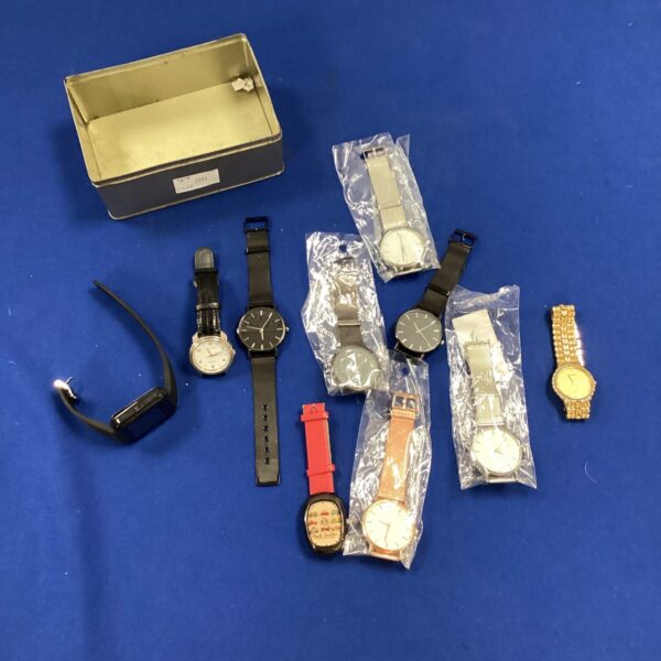 Assorted wrist watches in a tin, vintage timepieces.