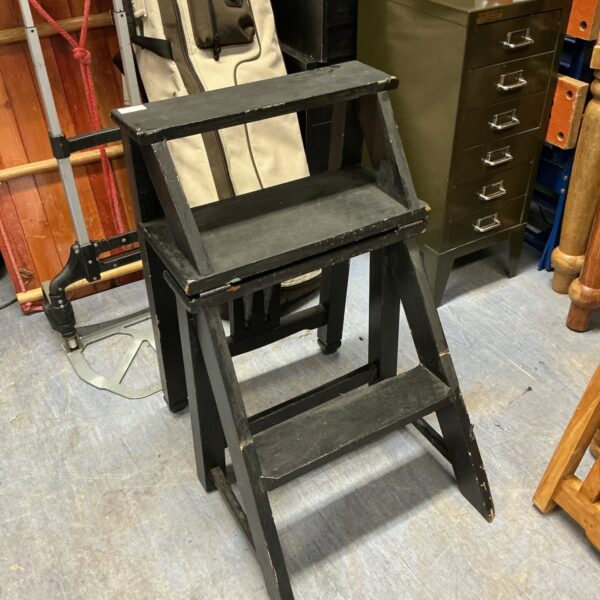 Vintage black folding step seat with rustic appeal.