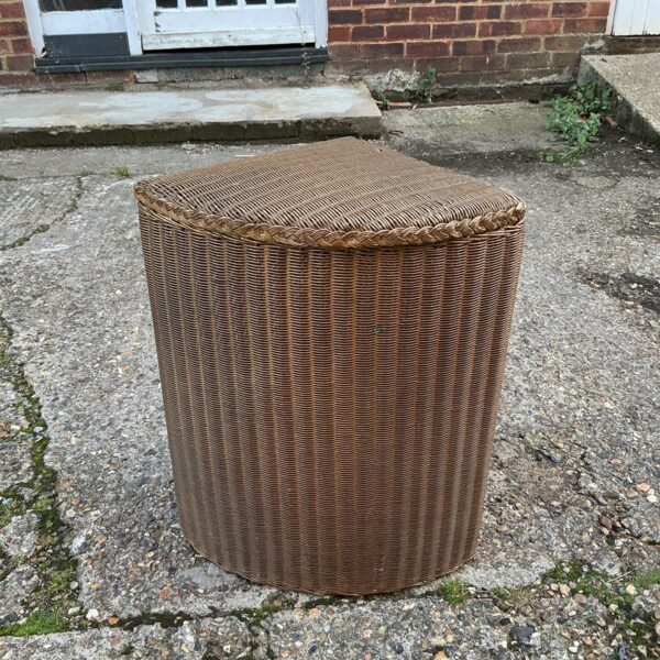 Vintage gold Lloyd Loom laundry basket for storage.