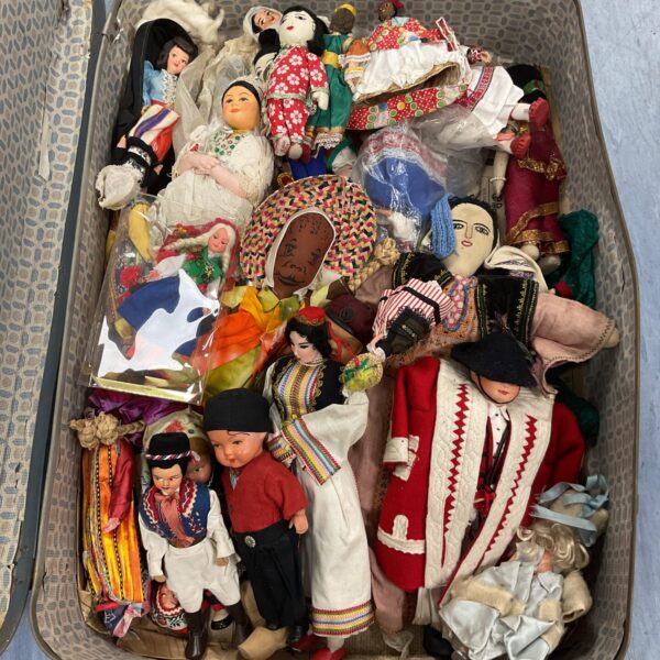 Large lot of vintage national costume dolls in a suitcase.