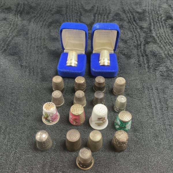 Collection of eight hallmarked silver thimbles on display.