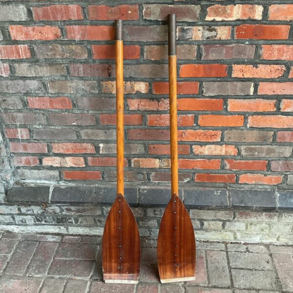 Pair of vintage wooden boat oars with warm patina.
