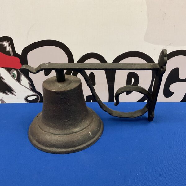 Vintage cast iron bell mounted on a wall, rustic farmhouse style.