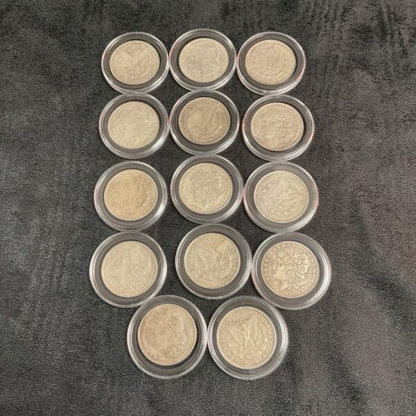 Set of fourteen silver-tone reproduction Morgan Dollar coins.