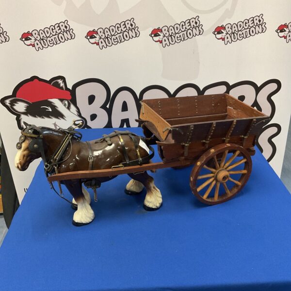 Detailed ceramic Shire horse with wooden cart for display.