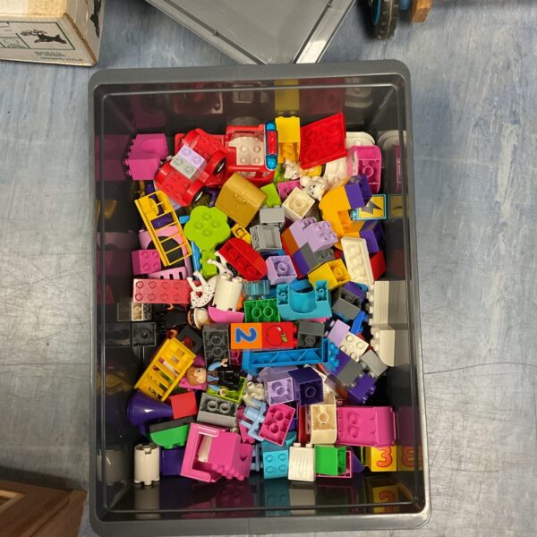 Colourful Lego Duplo blocks in a plastic storage container.