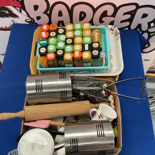 Mixed lot of kitchenware and spice jars for home cooking.