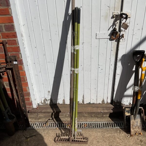 Lot of three vintage garden rakes with wooden handles.