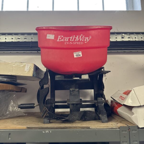 Vintage red Earthway garden seed spreader for lawn care.