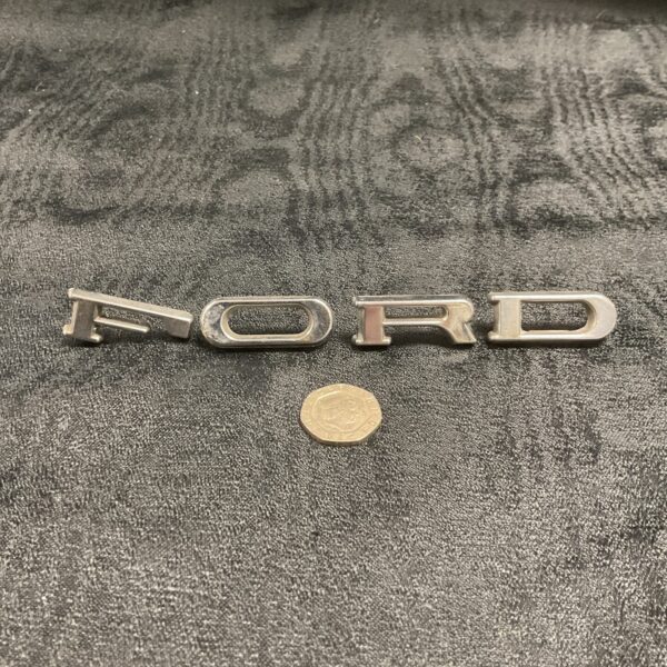 Vintage Ford chrome letters for classic car restoration.
