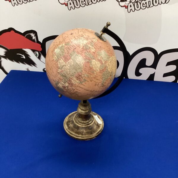Antique desk globe on wooden base, vintage geographical map.