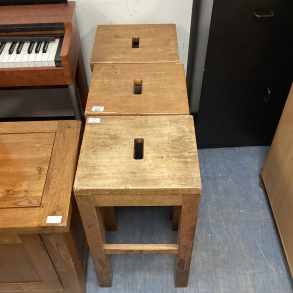 Set of three vintage laboratory stools in a classroom setting.