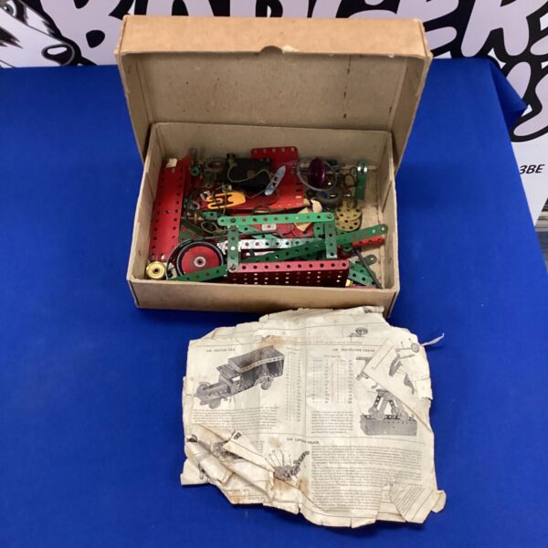Vintage Meccano set with various metal construction parts.