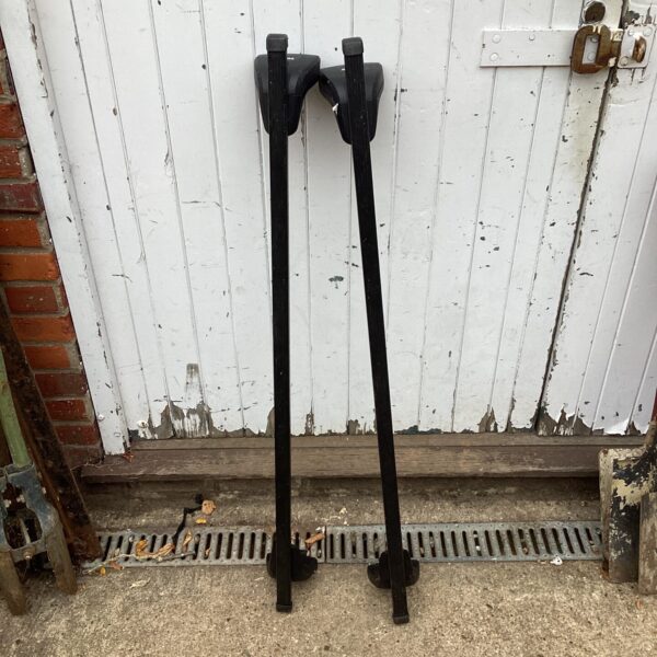 Black Thule car roof bars shown against a weathered door.