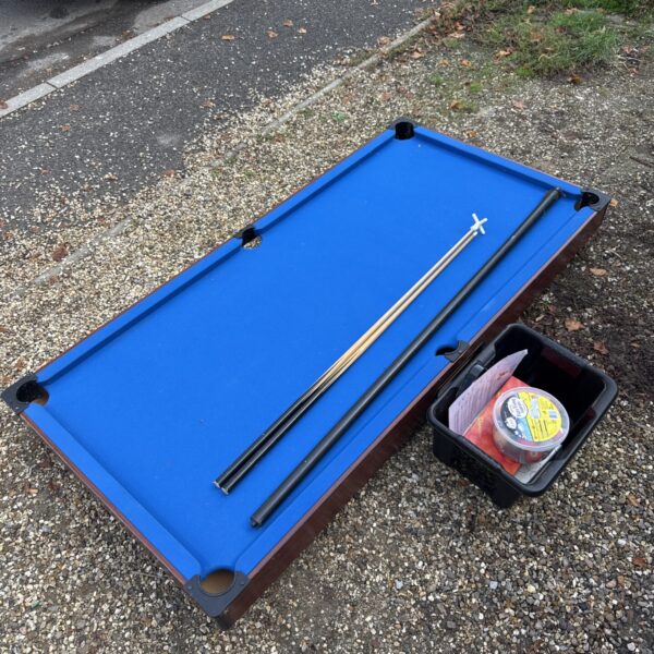 Blue snooker table with cues and balls for games room fun.