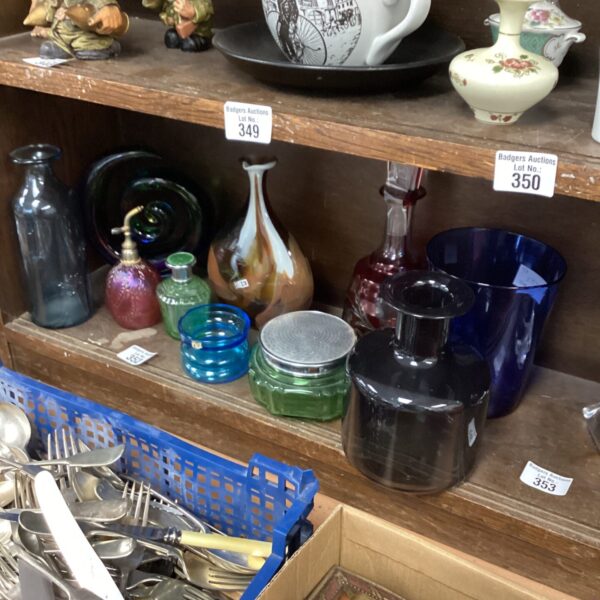 Collection of colourful vintage glass vases and bottles on display.