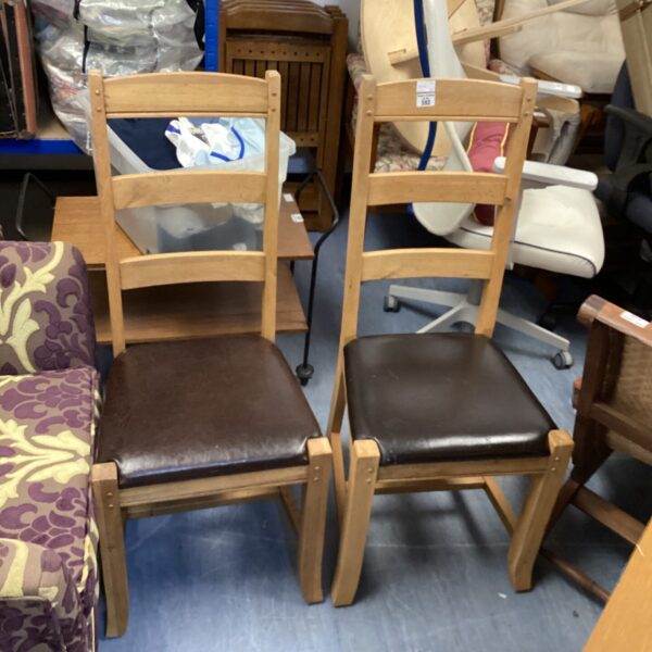 Pair of vintage wooden dining room chairs with upholstered seats.
