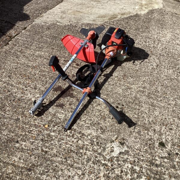 Side view of a petrol bush cutter for garden landscaping.