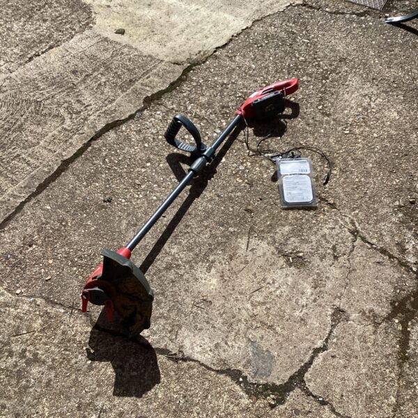 Sovereign cordless strimmer with charger for garden maintenance.