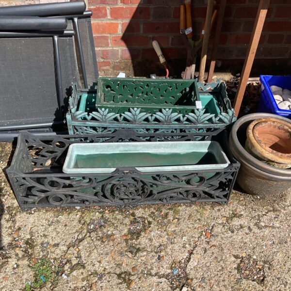 Vintage cast iron garden planter trough with floral design.
