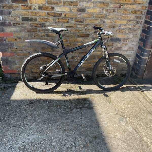 Side view of a dark-coloured Carrera Vulcan mountain bike.