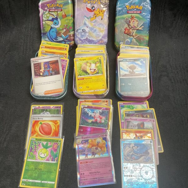 Lot of three Pokemon card tins for collectors.