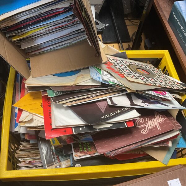 Large lot of 80s singles records in a crate and box.