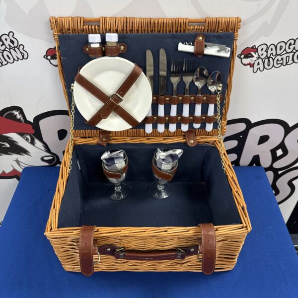Vintage picnic hamper set with wicker basket and dining ware.