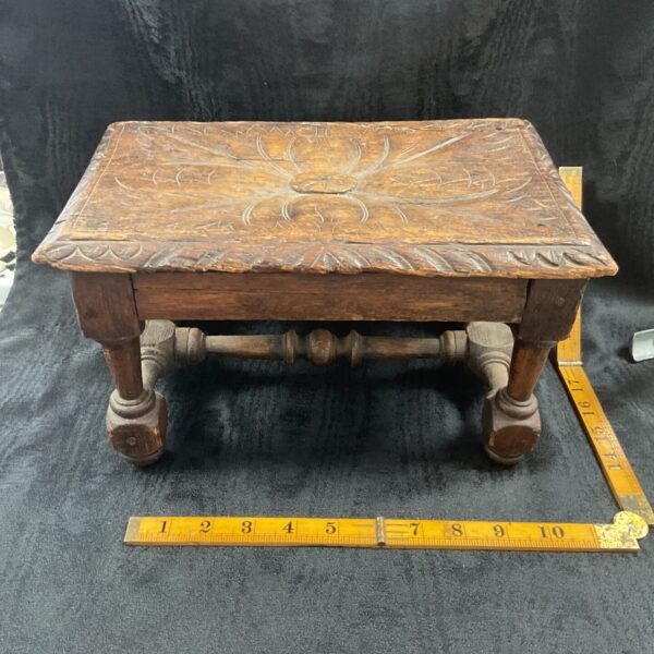 Antique carved oak miniature footstool with floral details.