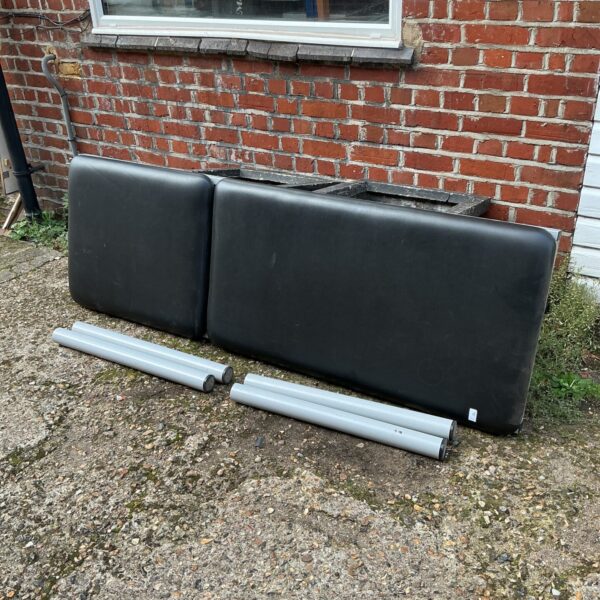 Black faux leather massage table sections for therapy or spa use.