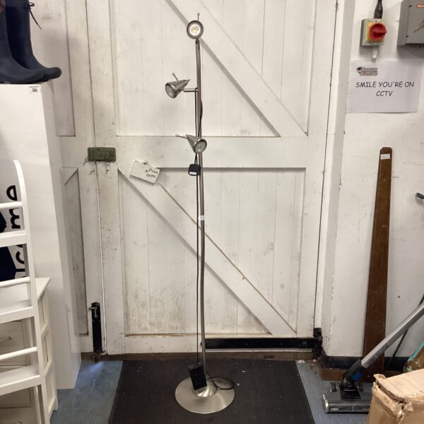 Sleek stainless steel standard lamp with adjustable head.