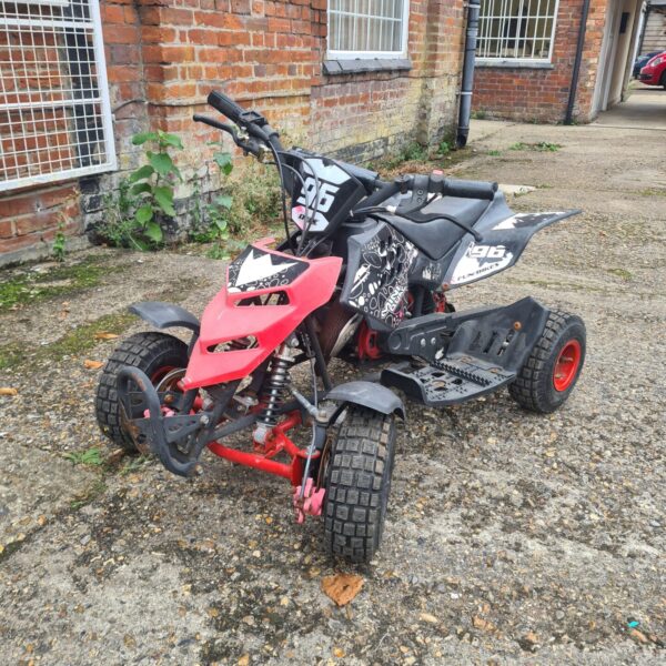 Red and black mini petrol quad bike, side view.