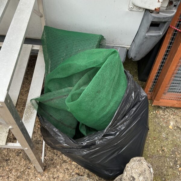 Green anti-heron pond cover netting in a black bag.