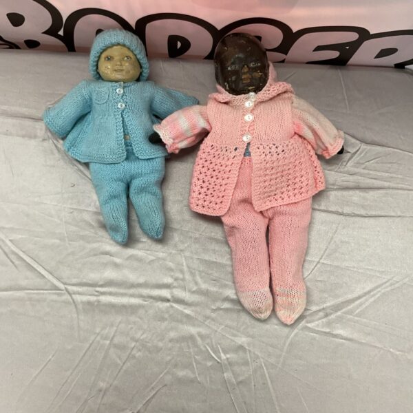 Antique doll pair in knitted outfits, vintage collectible toys.