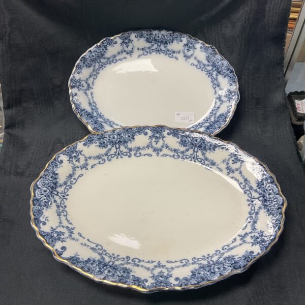 Antique flow blue platters by W. Adam’s & Co. displayed on a dark background.