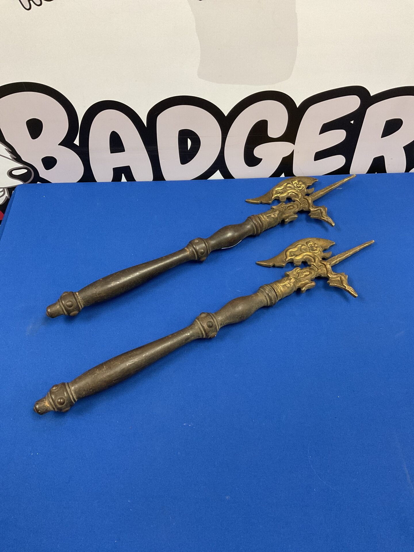 Antique iron fireplace poker with decorative handle.