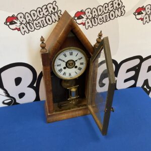 Side view of antique American spire clock with detailed wooden case.