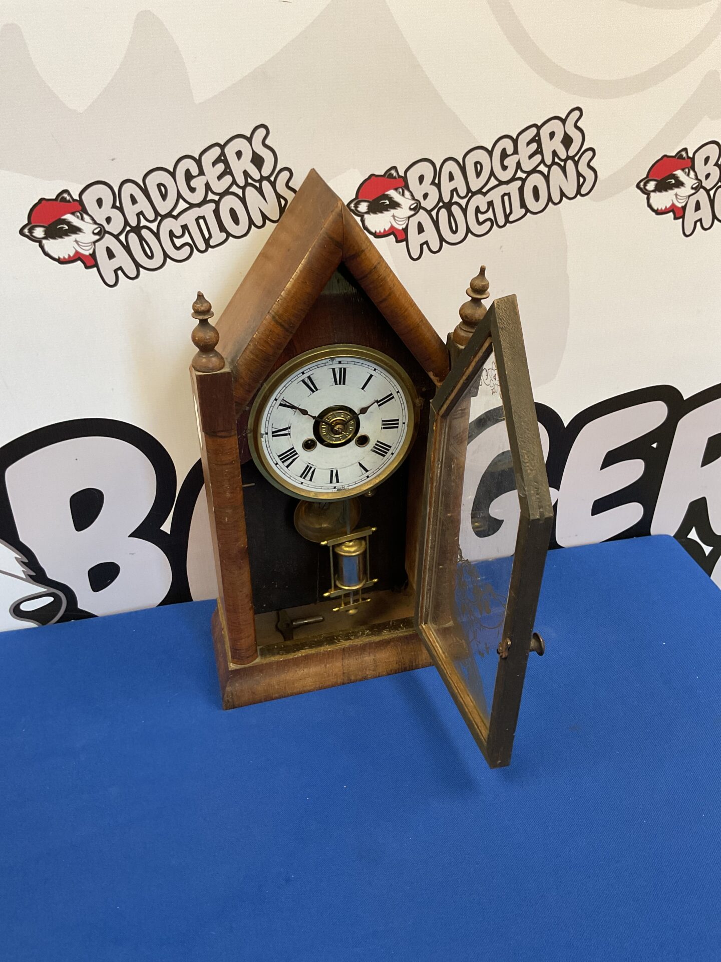 Side view of antique American spire clock with detailed wooden case.