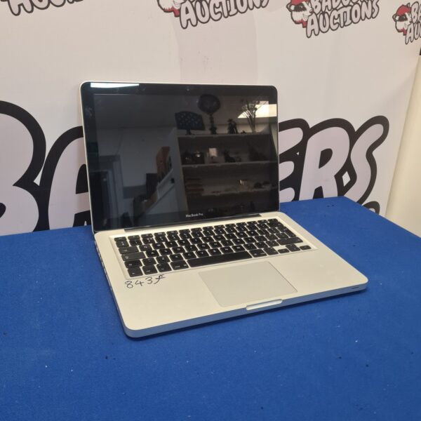 Silver Apple Macbook Pro A1278 laptop, open on a dark surface.