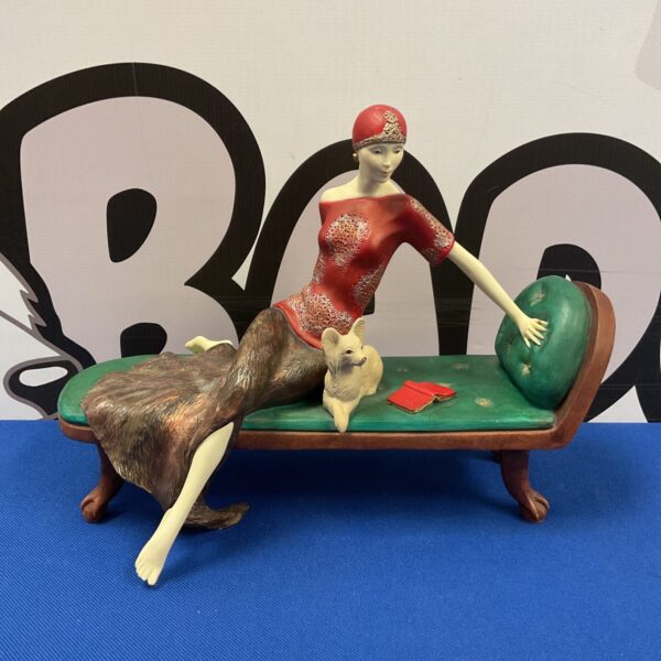 Vintage Art Deco lady figurine lounging on a chais lounge.
