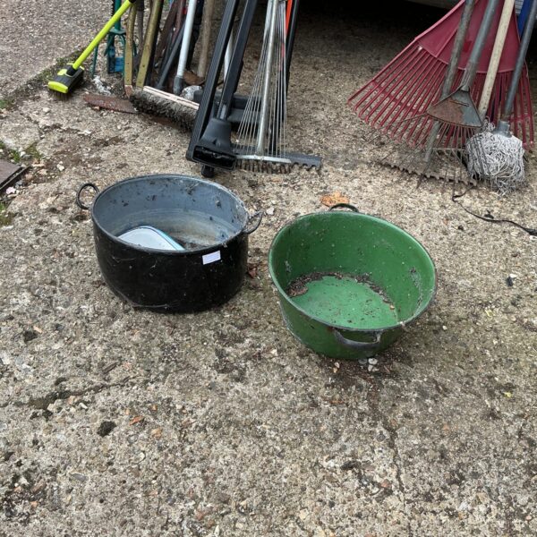 Black enamelled pot with other garden tools.