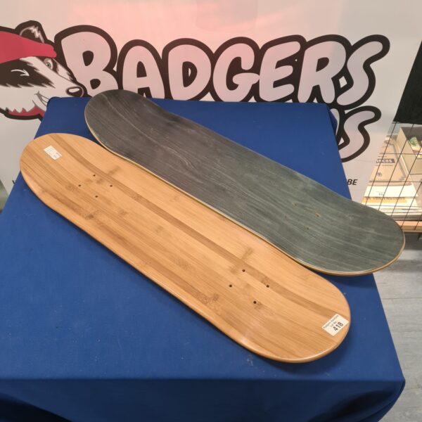 Pair of blank maple skateboard decks on blue backdrop.