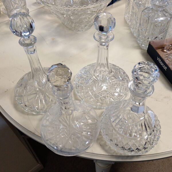 Lot of four vintage crystal ships decanters on a table.
