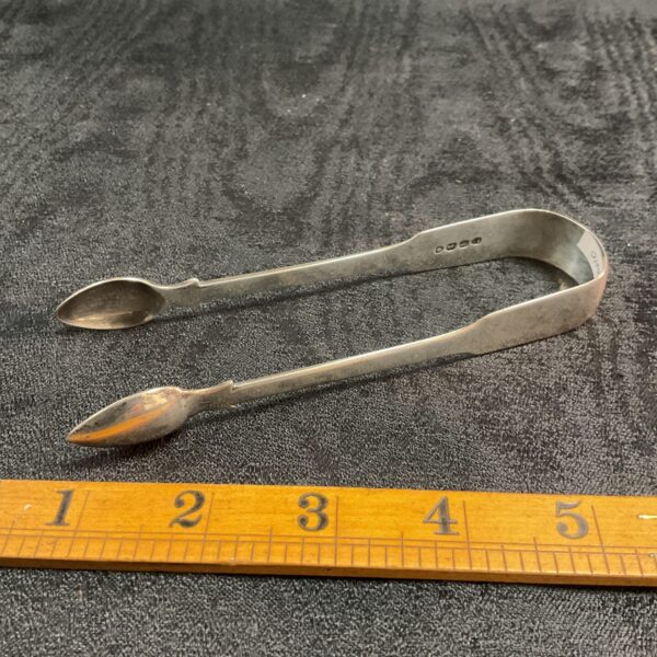 Close-up of antique Georgian sugar tongs in silver.